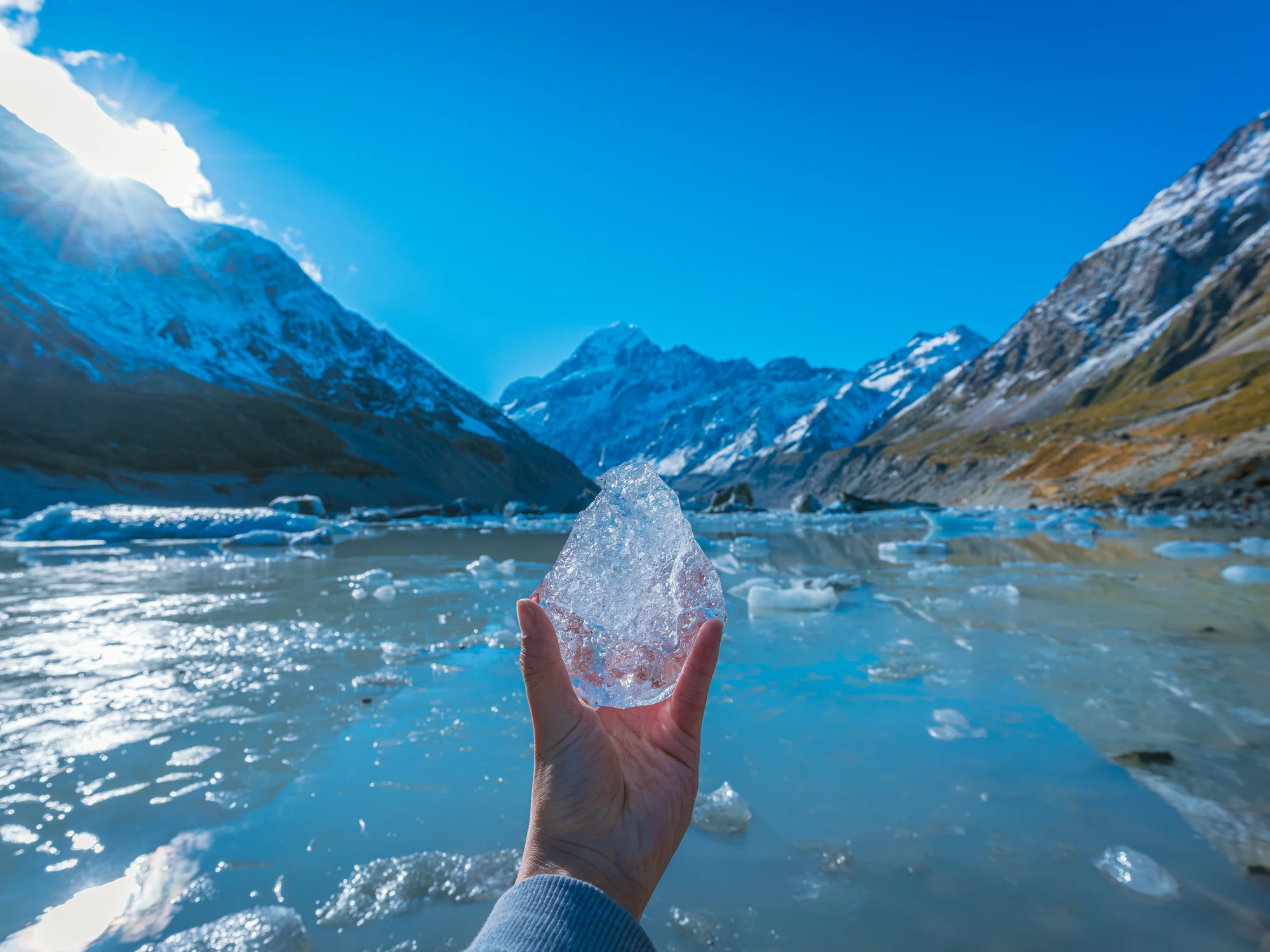 Glacial ice on Hooker Lake beneath snowy peaks